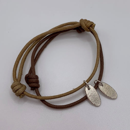 Brown and beige cotton cord bracelets each with textured silver petal charms